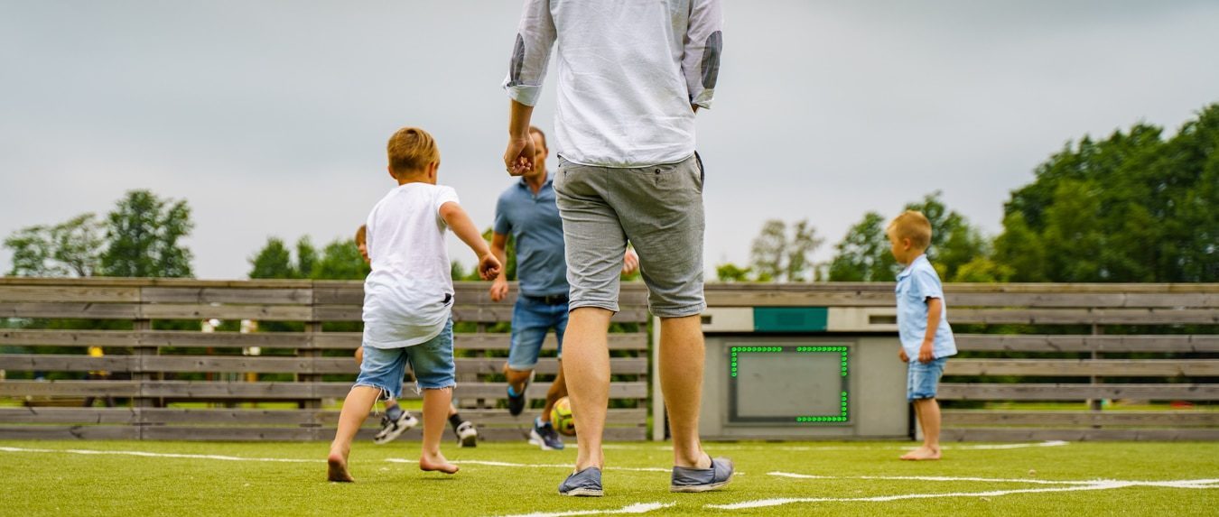 Toro. En digital ballbinge der far og tre barn spiller fotball. Foto